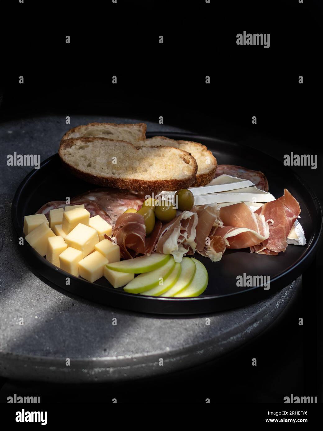 Platte mit Aufschnitt mit Käse, saurem Apfel, serrano-Schinken mit Oliven, geröstetem Brot, mexiko-lateinamerika Stockfoto
