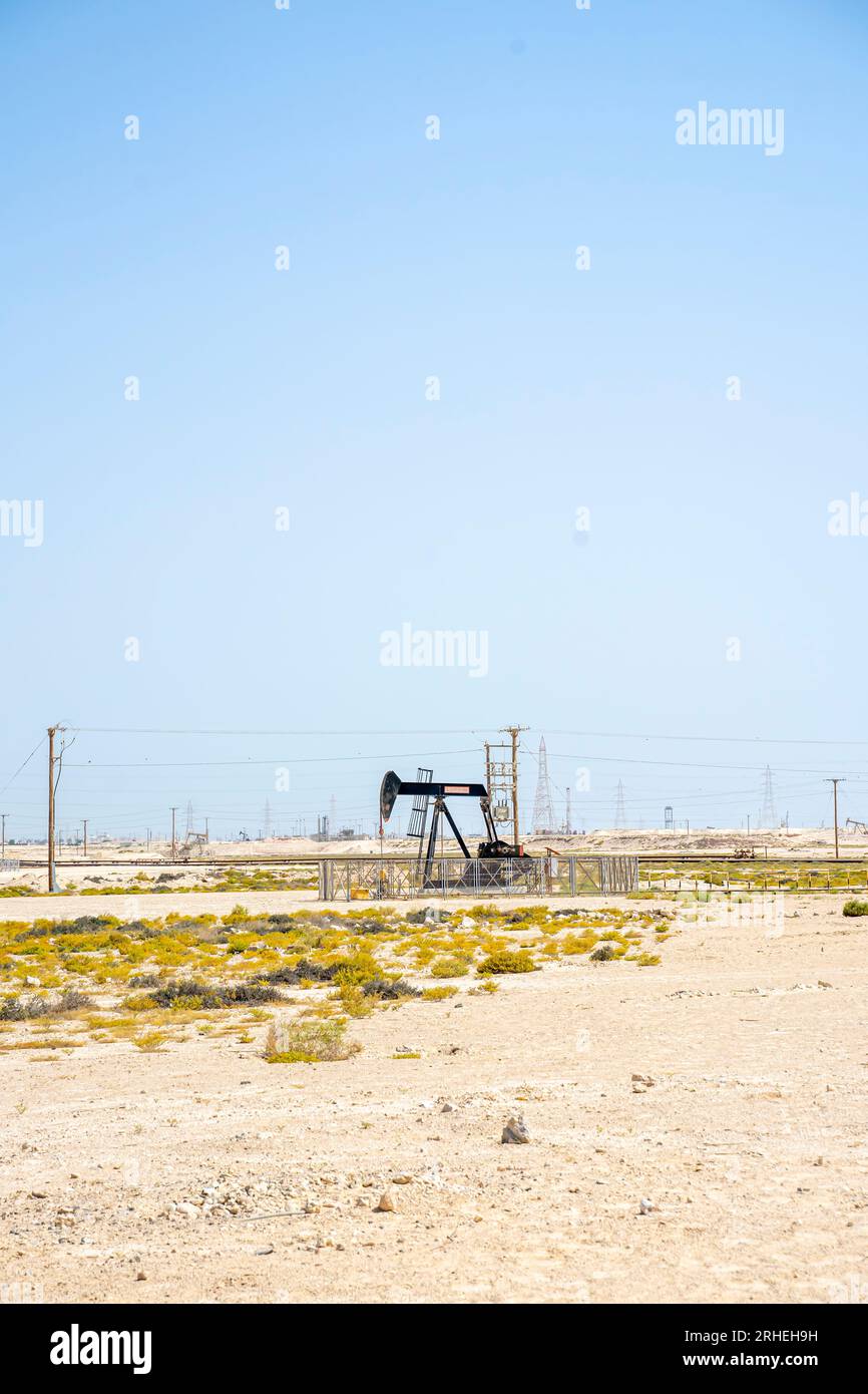 Infrastruktur des Bahrain-Ölfeldes - Pumpenheber, Ölpferd, Ölbock, Strahlpumpe zur Förderung von Rohöl aus der Ölquelle in der Wüste von Bahrain Stockfoto