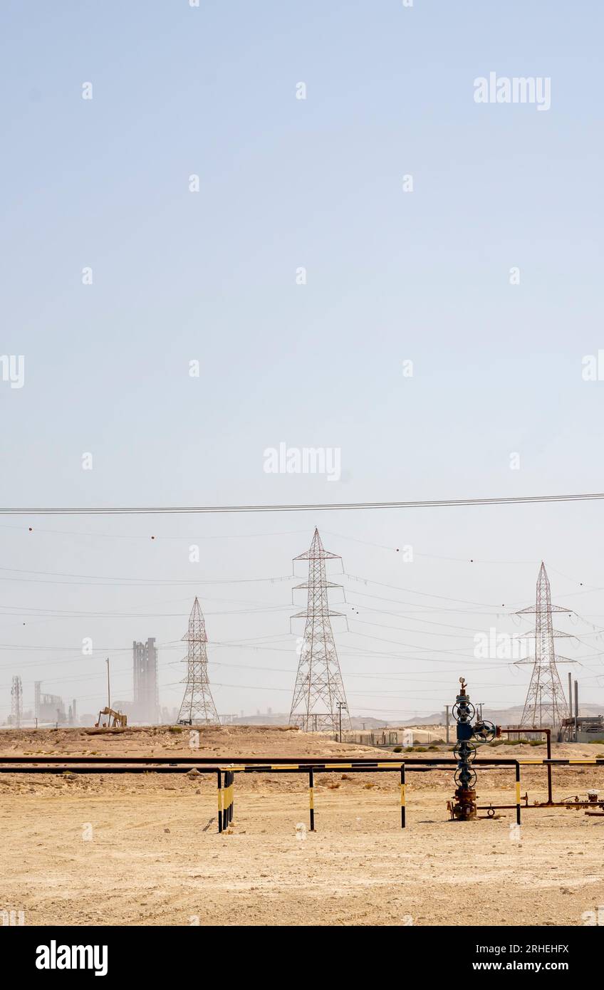 Infrastruktur des Erdölfeldes in Bahrain – elektrische Pole, Ölleitungen Stockfoto
