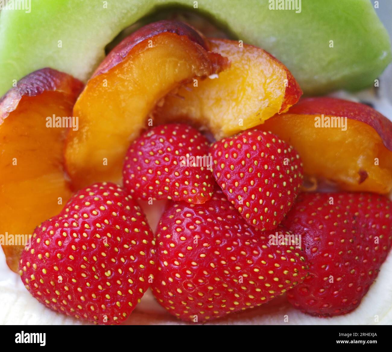 Ein gesundes Dessert mit frischen Erdbeeren, einer Melonenscheibe und Nektarinenscheiben. Stockfoto