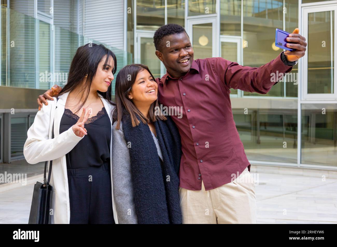 Glückliche Kollegen machen ein Selfie-Foto in der Arbeitspause. Gruppe junger Freunde, die im Büro im Freien lächeln. Ethnische Vielfalt. Stockfoto