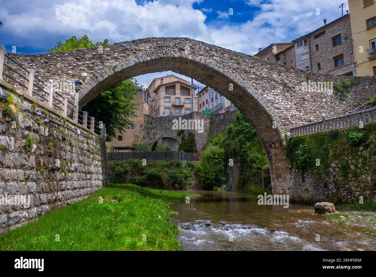 Antik und modern: Eine Straßenbrücke überspannt jetzt den Fluss Llobregat in La Pobla de Lillet in Katalonien, Spanien, neben der mittelalterlichen Pont Vell oder der alten Brücke Stockfoto