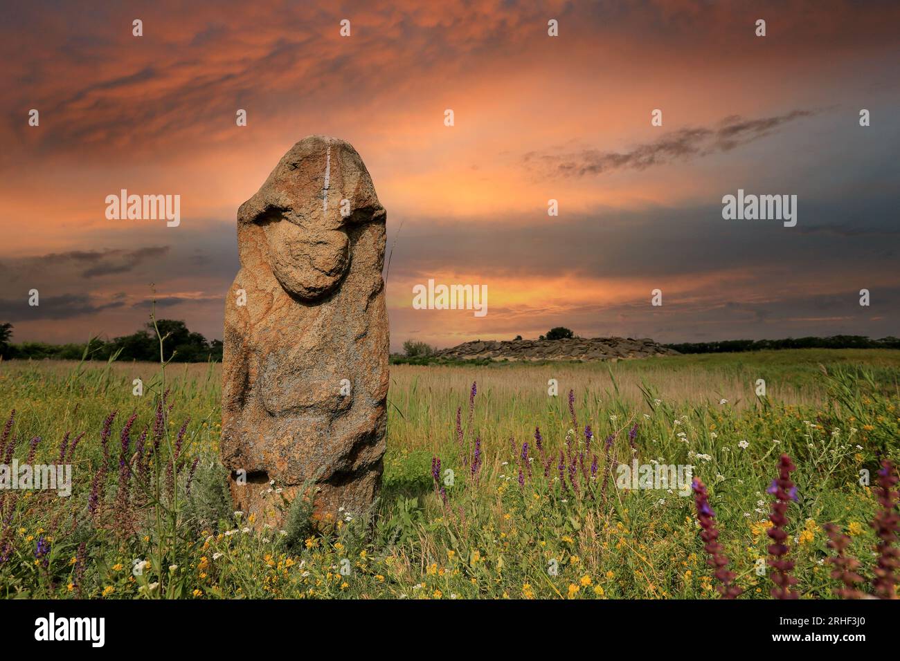 Steinidol in der Sommersteppe in der Ukraine auf rotem Himmel Hintergrund Stockfoto