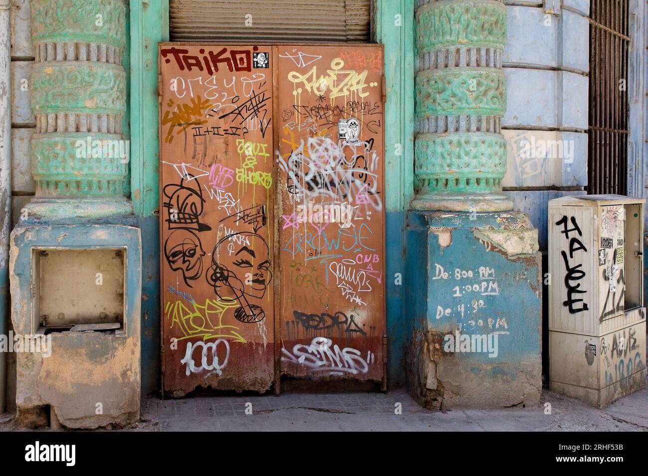 Havanna, Kuba, geschlossen und dreckige Metalltür mit Graffiti bedeckt. Das Gebäude befindet sich in einem Gebäude im Kolonialstil mit einer Veranda. Stockfoto