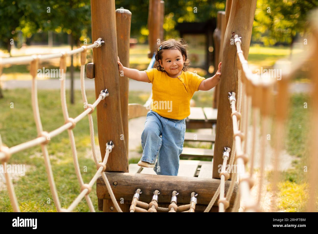 Asiatisches Kleinkind, Das Allein Auf Dem Spielplatz Im Park Spaß Hat Stockfoto
