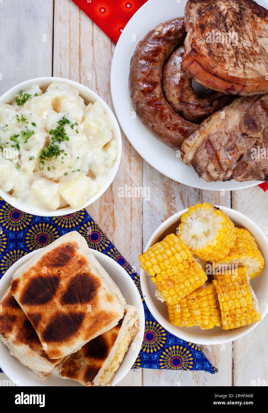 Südafrikanischer Braai-Tag oder Heritage Day. Traditionelles Braai-Essen wird gefeiert. Fleisch und Beilagen mit traditionellem Shwe - Shwe Tuch. Stockfoto