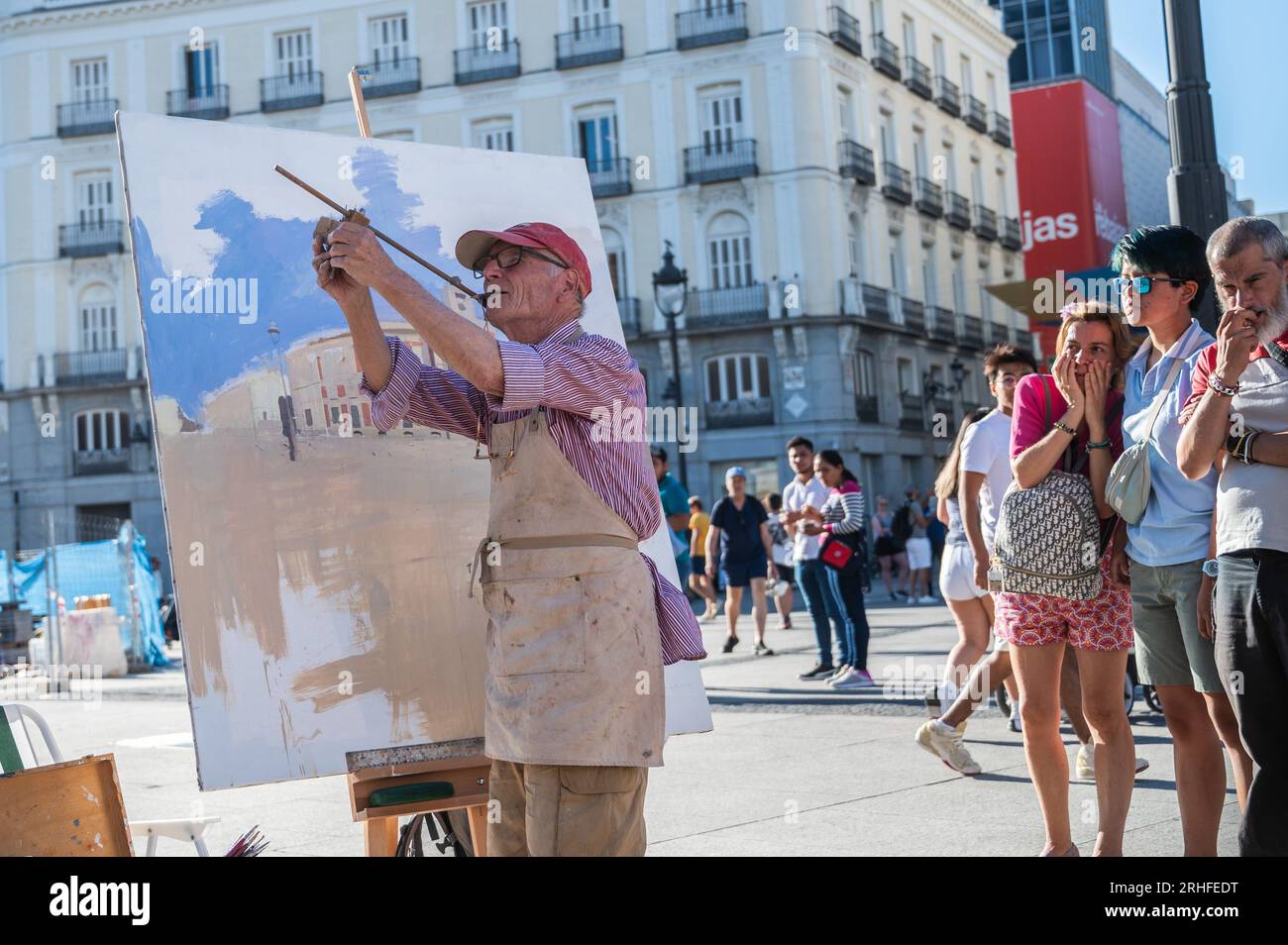 Madrid, Spanien. 16. Aug. 2023. Der berühmte spanische Maler und Bildhauer Antonio Lopez arbeitet an einem neuen Kunstwerk auf dem Sol Square im Zentrum von Madrid, während ihn Einheimische und Touristen beobachten. Kredit: Marcos del Mazo/Alamy Live News Stockfoto