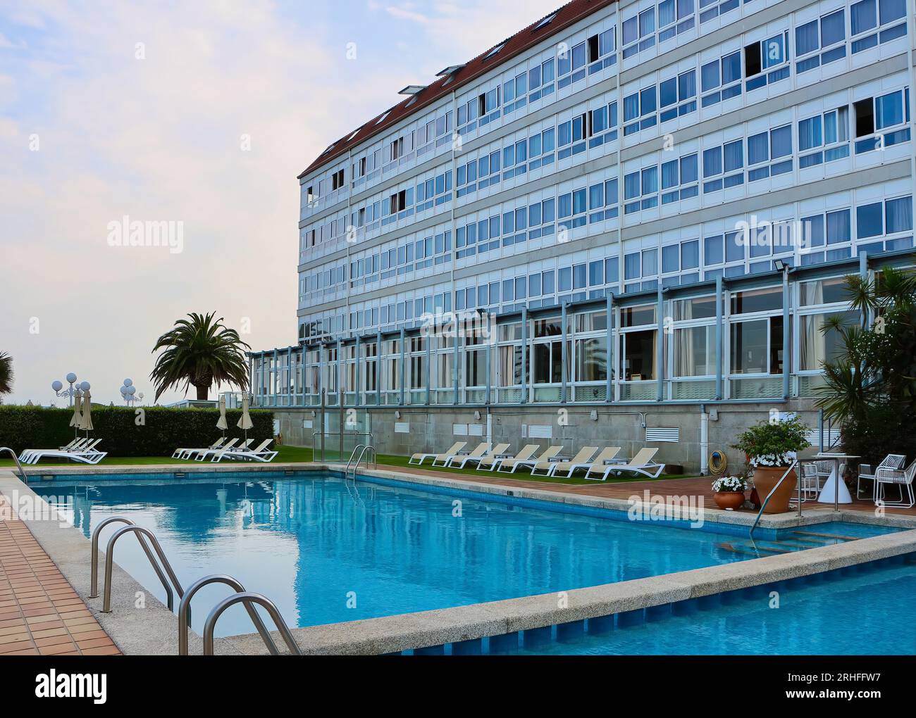Leere Liegestühle neben dem Swimmingpool im Abendlicht hinter dem Hotel Louxo 4-Sterne-Hotel La Toja Island Pontevedra Galicia Spanien Stockfoto