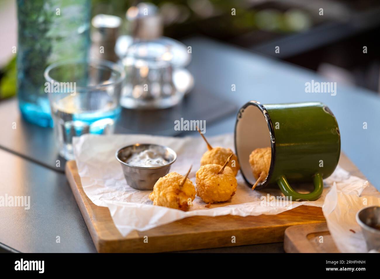 Frittierte Käsebällchen. Käsebällchen in einem altmodischen Becher. Käsebällchen werden in einem Restaurant auf dem Tisch serviert. Stockfoto