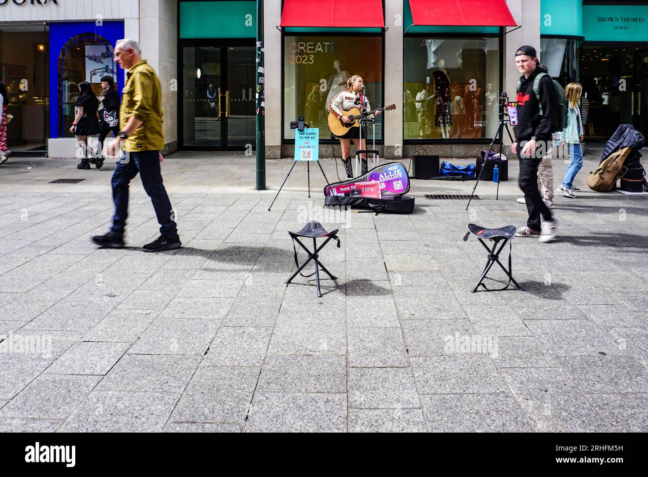 Allie Sherlock Busking auf der Grafton Street, Dublin, Irland. Spenden werden über einen QR-Code oder einen 3-Euro-Smartphone-Tap angefordert. Stockfoto