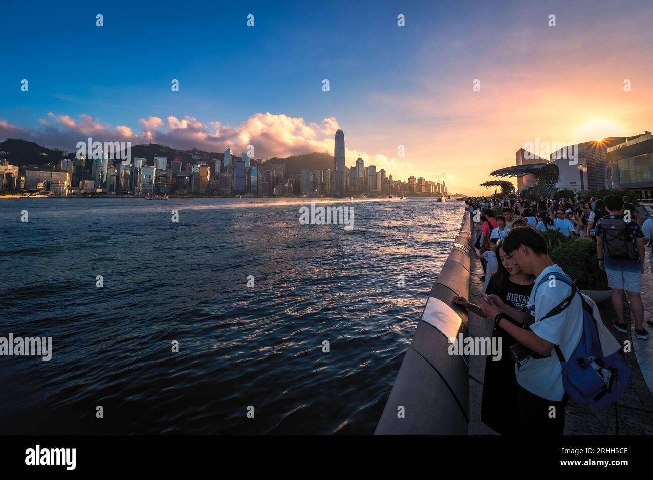 Fantastischer Blick auf die Avenue of Stars und Hongkongs fantastische Skyline mit ihren beeindruckenden Wolkenkratzern vor einem dramatischen Sonnenuntergang, Hongkong, China Stockfoto