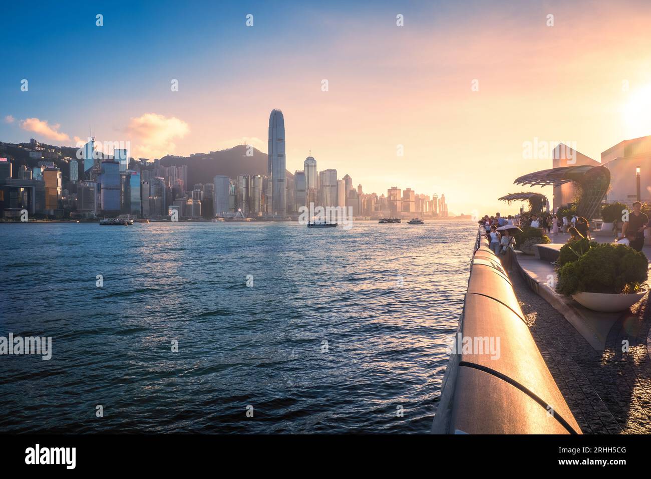 Fantastischer Blick auf die Avenue of Stars und Hongkongs fantastische Skyline mit ihren beeindruckenden Wolkenkratzern vor einem dramatischen Sonnenuntergang, Hongkong, China Stockfoto