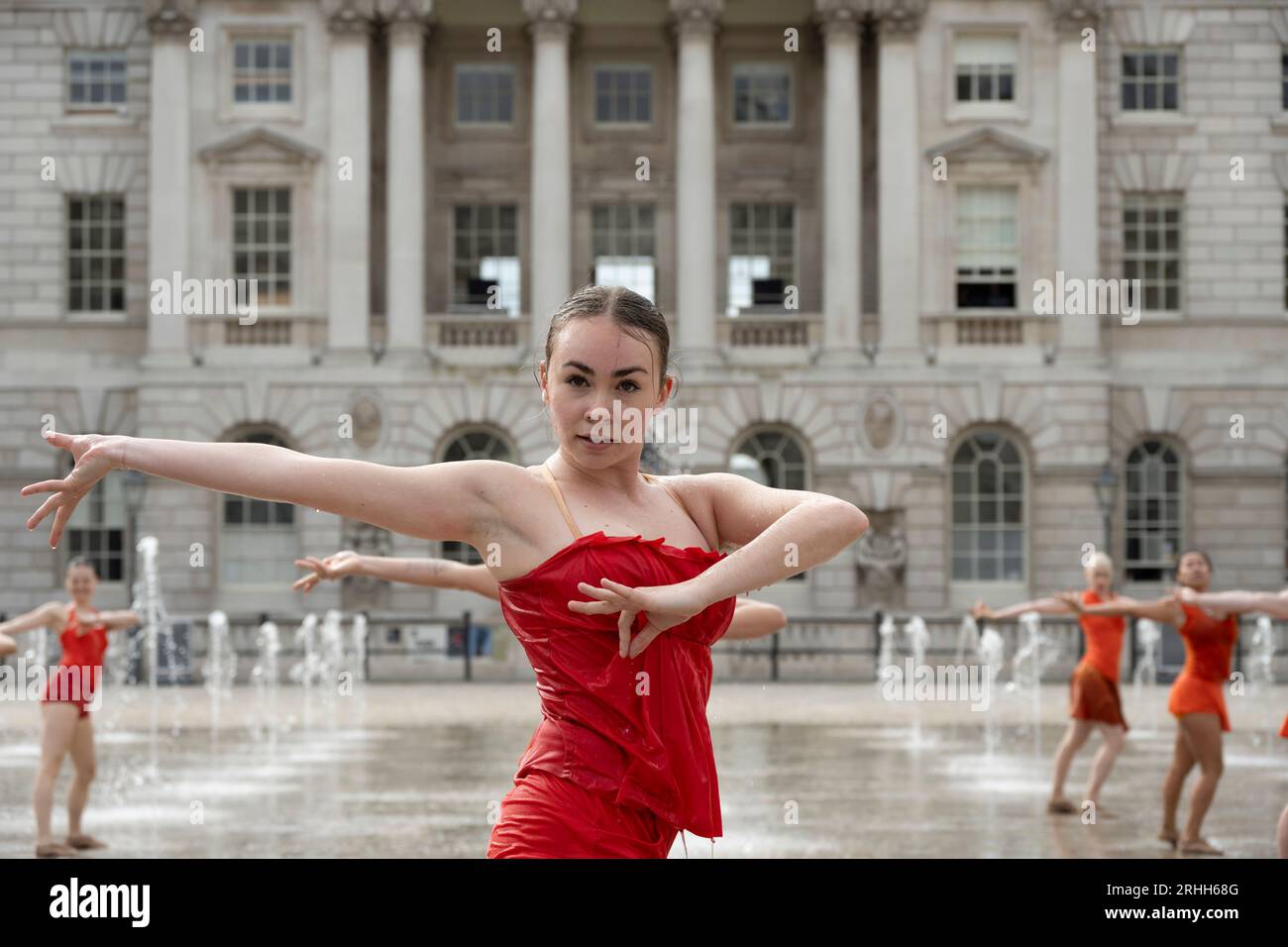 Somerset House, London, Großbritannien. Aug. 2023. 22 Tänzerinnen in leuchtend orangen Kostümen, die von Ursula Bombshell entworfen wurden, tanzen in den Springbrunnen des Somerset House in einer Kostümprobe für Shobana Jeyasinghs Kontrapunkt. Am Wochenende des 19-20. August werden acht Aufführungen von Kontrapunkt stattfinden, die Teil des Somerset House’s Summer in the Courtyard und des Inside Out Festivals des Westminster City Council sind. Quelle: Malcolm Park/Alamy Live News Stockfoto