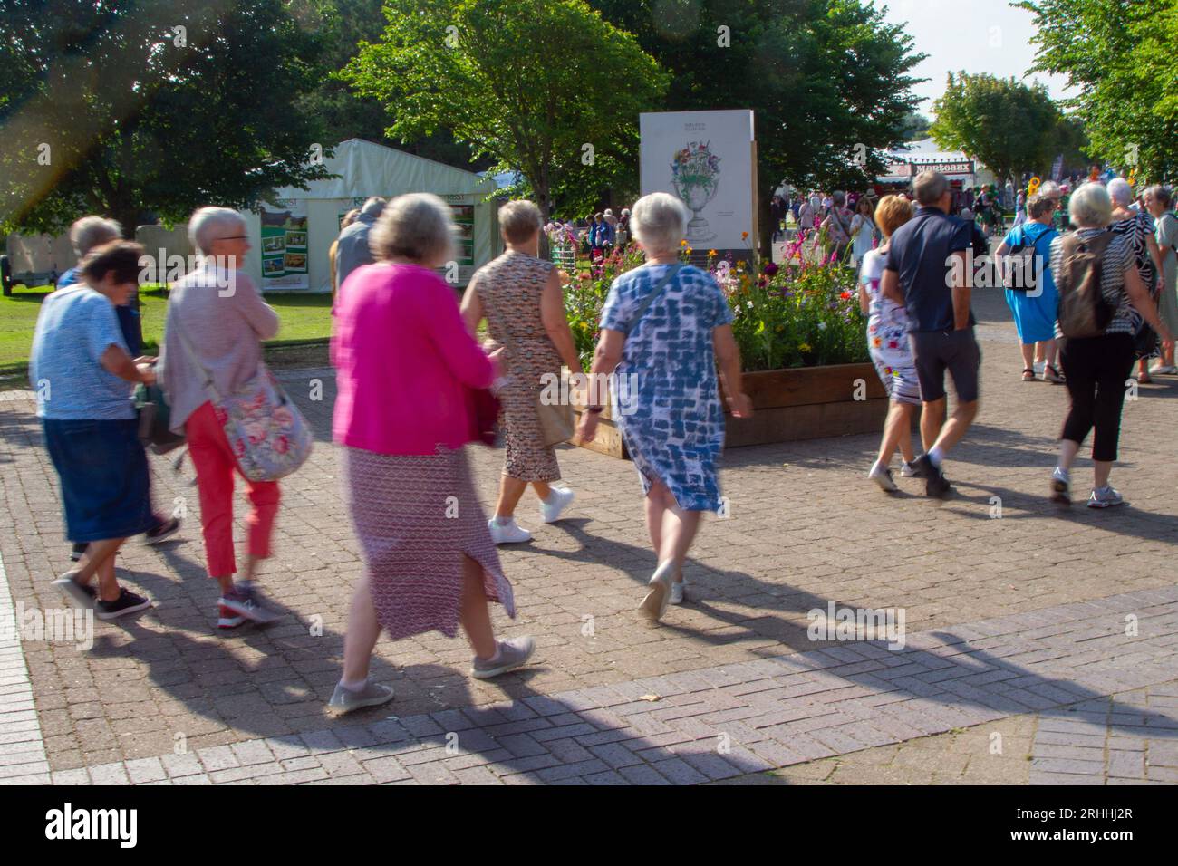Southport, Merseyside. August 2023 Wetter in Großbritannien. Ein sonniger Start in den Nordwesten, wenn die Gäste für die viertägige spektakuläre Blumenshow ankommen, um von bunten G-Models in leuchtenden Kostümen begrüßt zu werden. Schmetterlingsmädchen, Blumen-, Stelzenläufer und grüne Blumenbechermänner begrüßen Besucher der botanischen Extravaganz. Credit; MediaWorldImages/AlamyLiveNews Stockfoto