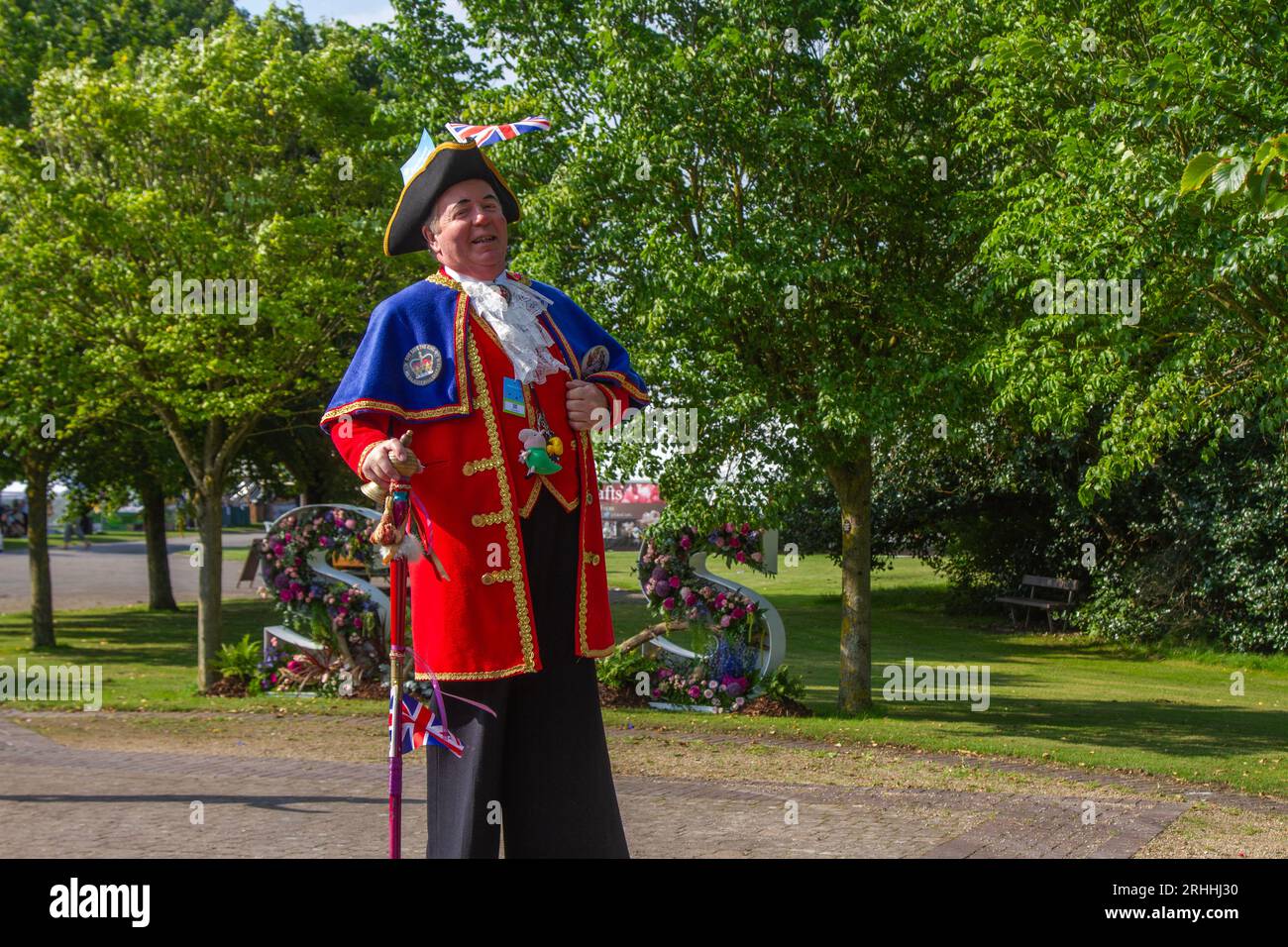 Southport, Merseyside. August 2023 Wetter in Großbritannien. Ein sonniger Start in den Nordwesten, wenn die Gäste für die viertägige spektakuläre Blumenshow ankommen, um von bunten G-Models in leuchtenden Kostümen begrüßt zu werden. Professor Crump begrüßt Besucher der botanischen Extravaganz. Credit; MediaWorldImages/AlamyLiveNews Stockfoto