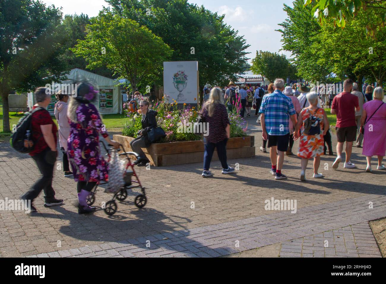 Southport, Merseyside. August 2023 Wetter in Großbritannien. Ein sonniger Start in den Nordwesten, wenn die Gäste für die viertägige spektakuläre Blumenshow ankommen, um von bunten G-Models in leuchtenden Kostümen begrüßt zu werden. Schmetterlingsmädchen, Blumen-, Stelzenläufer und grüne Blumenbechermänner begrüßen Besucher der botanischen Extravaganz. Credit; MediaWorldImages/AlamyLiveNews Stockfoto