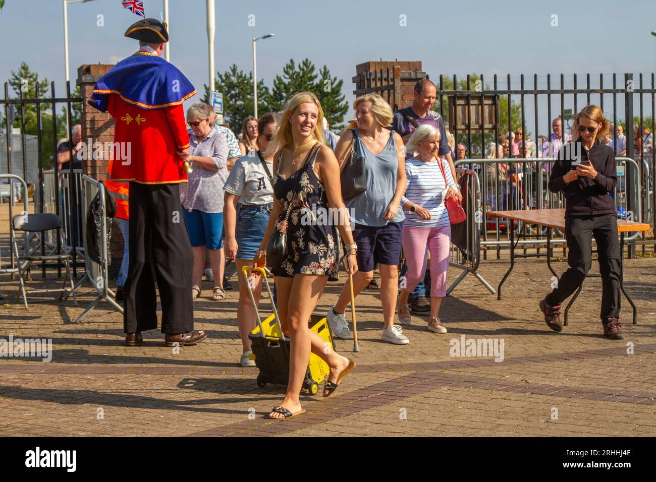 Begrüßung bei der Southport Flower Show, Merseyside. August 2023 Wetter in Großbritannien. Ein sonniger Start im Nordwesten, wenn die Besucher zu der viertägigen spektakulären Blumenschau kommen, wo sie von mehrfarbigen G-Models in bunten Kostümen begrüßt werden. Schmetterlingsmädchen, Blumenläuferinnen, Stelzenläufer und grüne Blumentöpfe begrüßen die Besucher der botanischen Extravaganz. Stockfoto