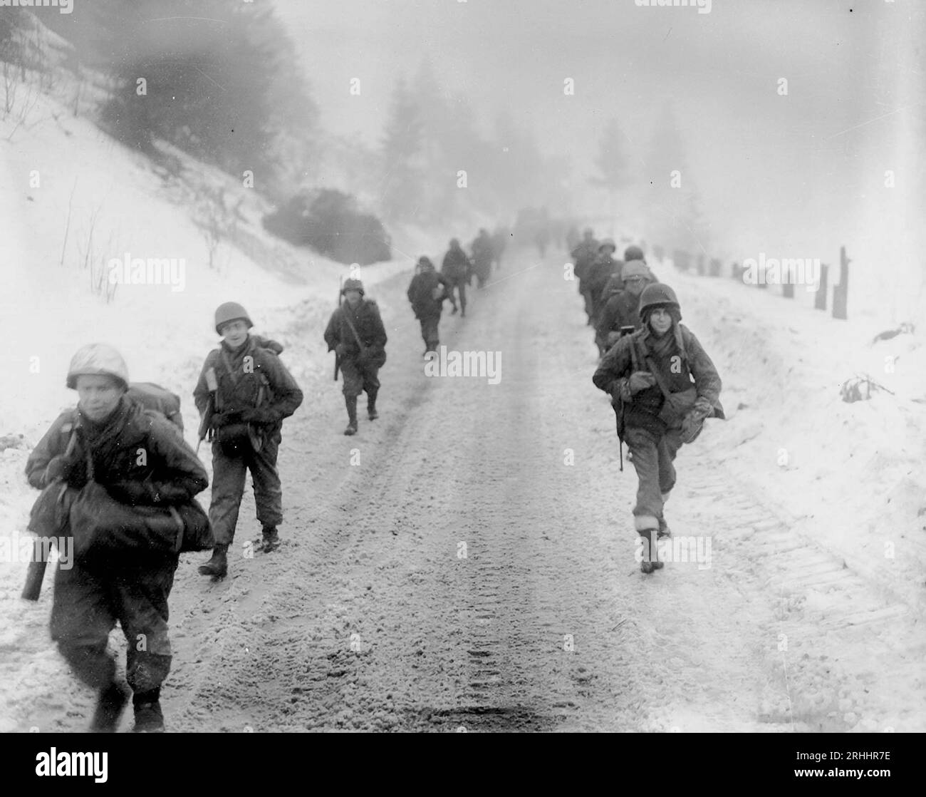 BEI MURRINGEN, BELGIEN - 31. Januar 1945 - marschieren US-Truppen der 1. Division durch Schnee in Richtung Murringen, Belgien, nach einem großen deutschen Verein Stockfoto