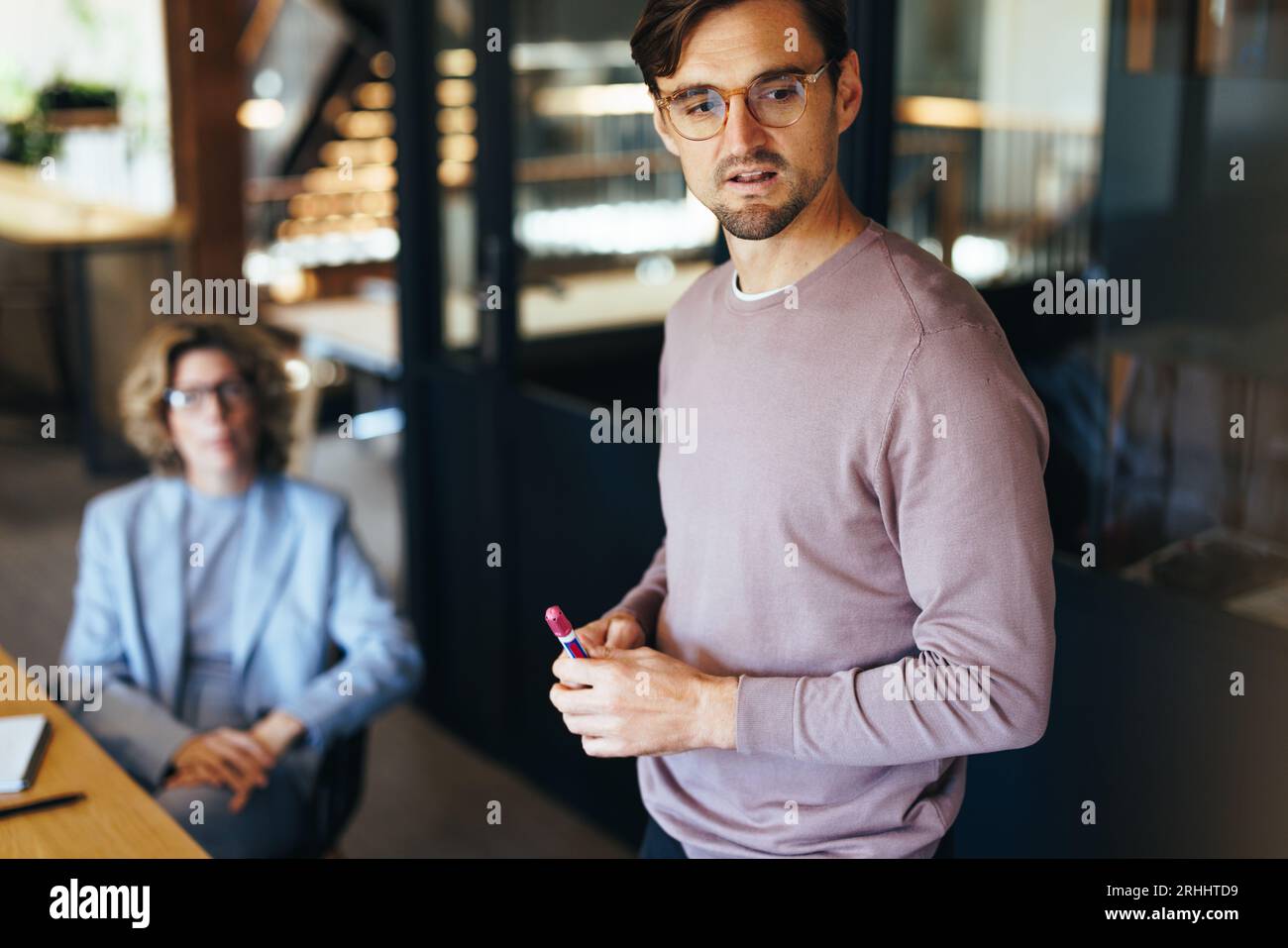 Geschäftsmann hält eine Präsentation in einem Team-Meeting. Männlicher Profi, der mit seinen Kollegen spricht. Team von Fachleuten, die gemeinsam arbeiten Stockfoto
