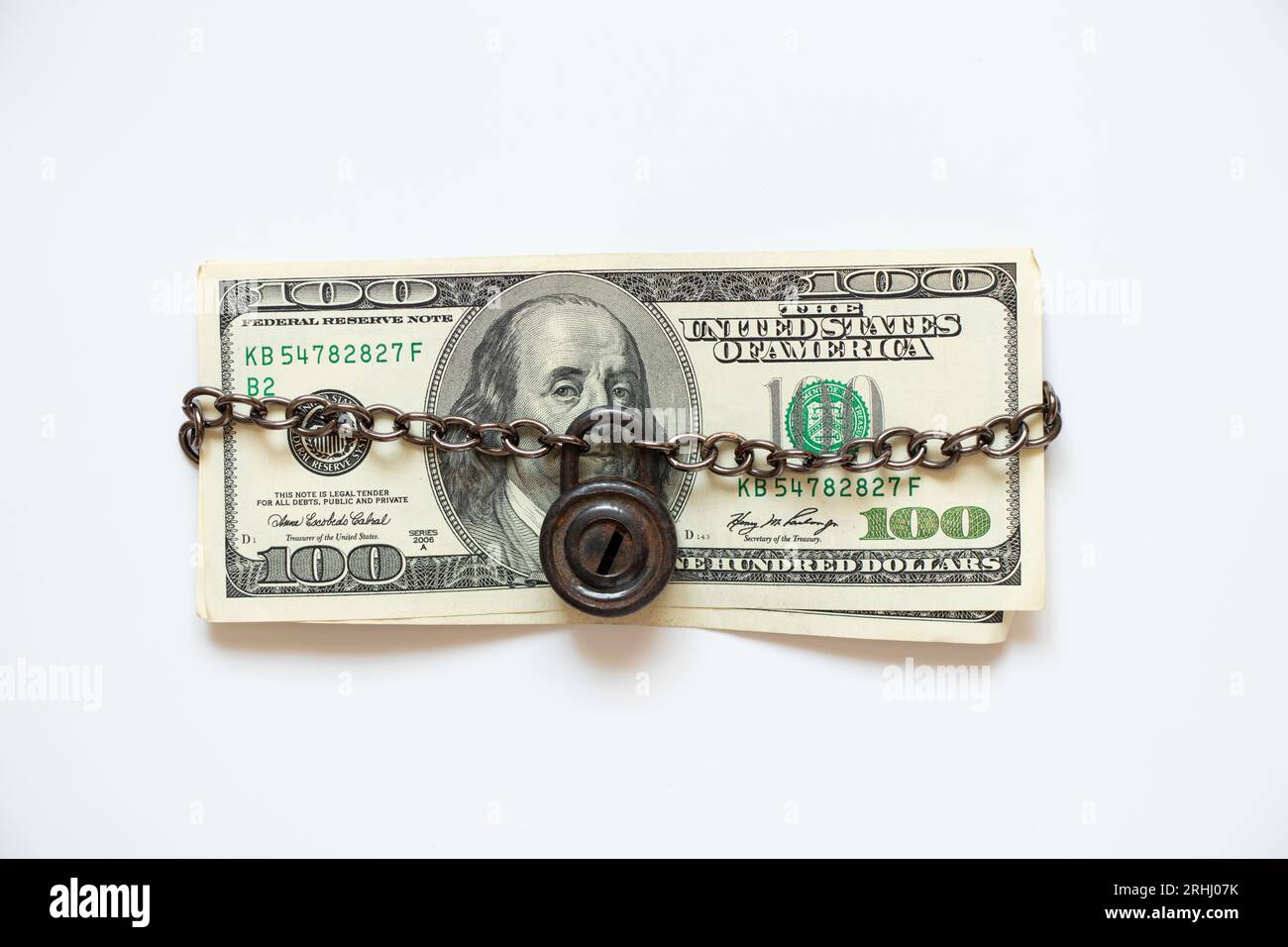 100 Dollar für eine Kette unter Verschluss und Schlüssel auf weißem Hintergrund, Geschäft und Finanzen Stockfoto