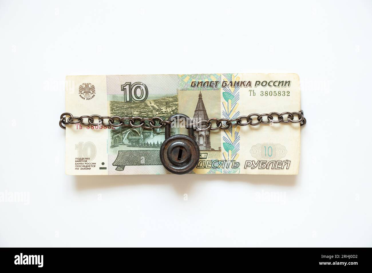 Zehn russische Rubel auf einer Kette unter Verschluss und Schlüssel auf weißem Hintergrund, Geschäft und Finanzen, Sanktionen und Zahlungsausfall, der Zusammenbruch des Rubels Stockfoto