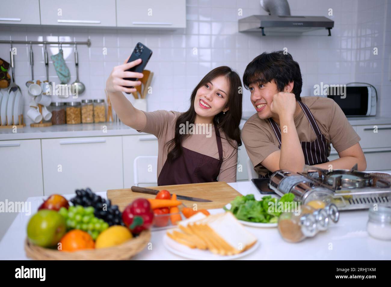 Das junge Paar ist in der Küche im Livestreaming. Lifestyle- und Freizeitkonzept. Stockfoto