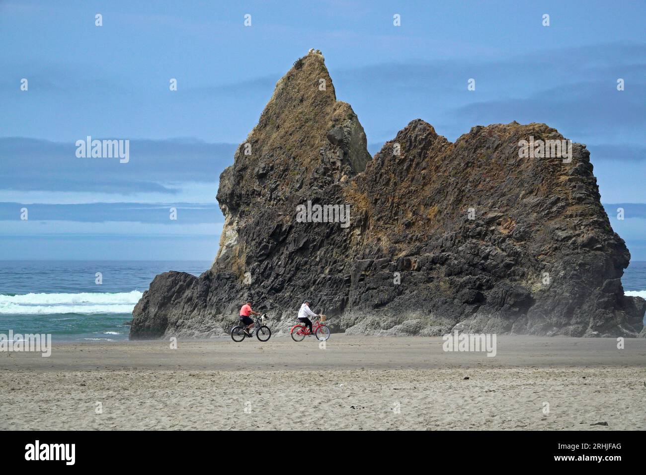 Eine ältere Familie reitet Fahrräder am Strand in der Nähe des Hug Point State Park an der Oregon Pacific Coast. Stockfoto