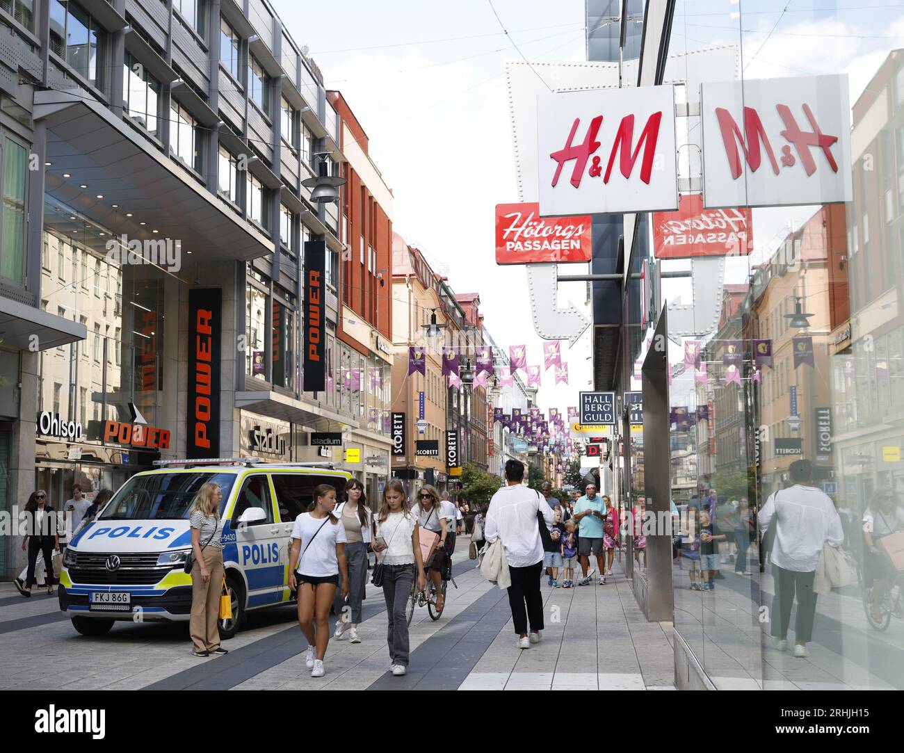 Stockholm, Schweden. Aug. 2023. Ein Polizeiauto ist unter Fußgängern in der schwedischen Hauptstadt Stockholm am 17. August 2023 zu sehen. Die terroristische Bedrohung in Schweden wurde von „erhöht“ auf „hoch“ angehoben, sagte der schwedische Sicherheitsdienst (SAPO) am Donnerstag. Quelle: Wei Xuechao/Xinhua/Alamy Live News Stockfoto