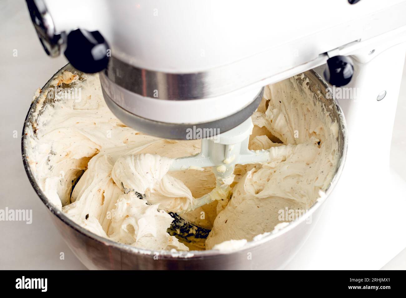 Mischen von Vanilla Buttercream-Zuckerguss in einem Standmixer Mixer: Zuckerguss in einem Standmixer mit Paddelaufsatz Stockfoto