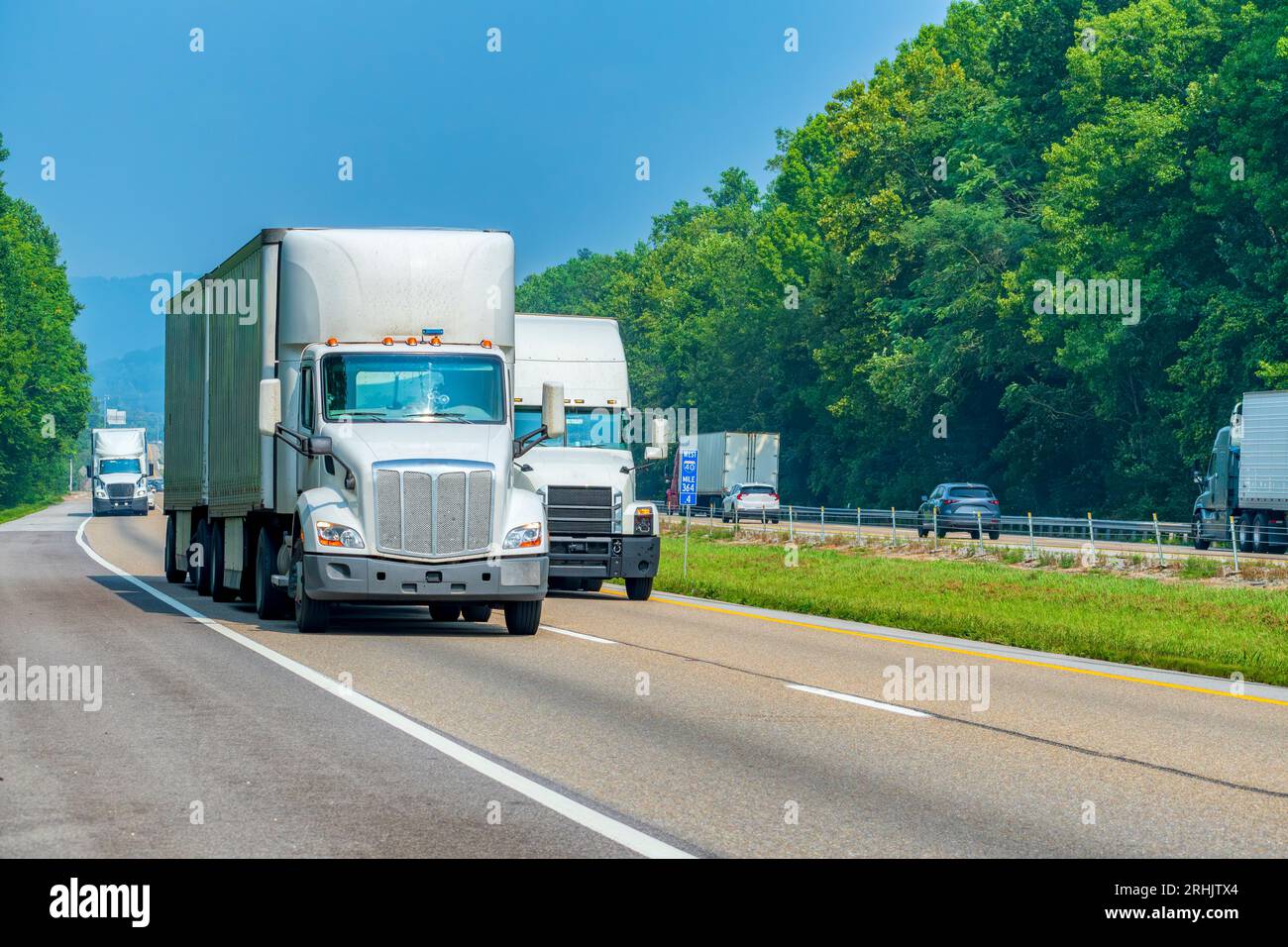 Horizontale Aufnahme von drei weißen Semis auf der interstate mit Kopierraum. Stockfoto