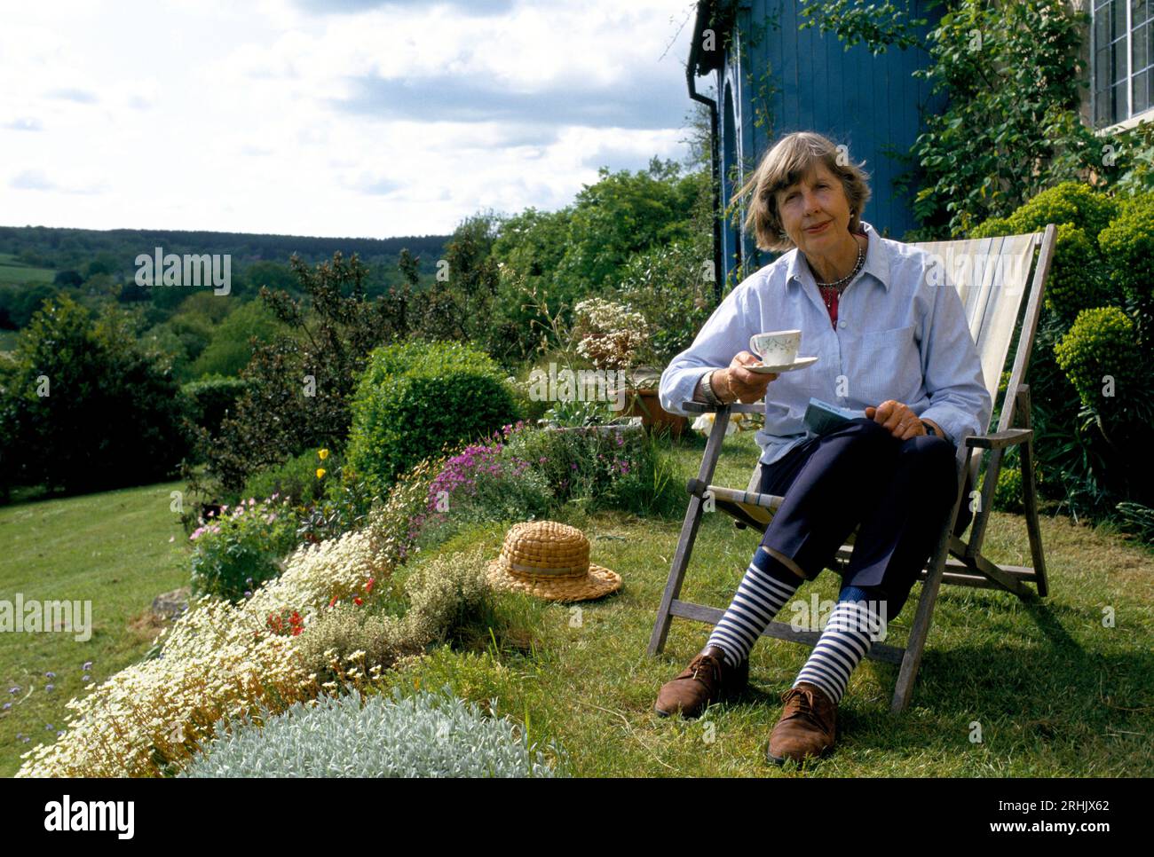 Pensionierung eine Tasse Tee UK Landscape 1990er Jahre Ältere Frau in ihrem Garten eine Rentnerin, die das warme Sommerwetter Somerset, England, genießt. Etwa im Juni 1990 HOMER SYKES Stockfoto