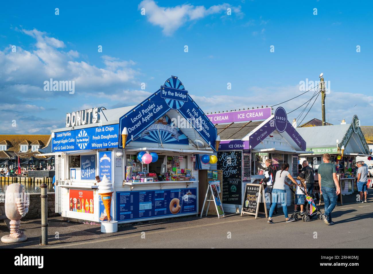 Meeresfrüchte-, Fisch- und Chip-Shacks in einem britischen Badeort, West Bay, Dorset. Traditionelle britische Urlaubskultur. Fastfood im Freien. Stockfoto