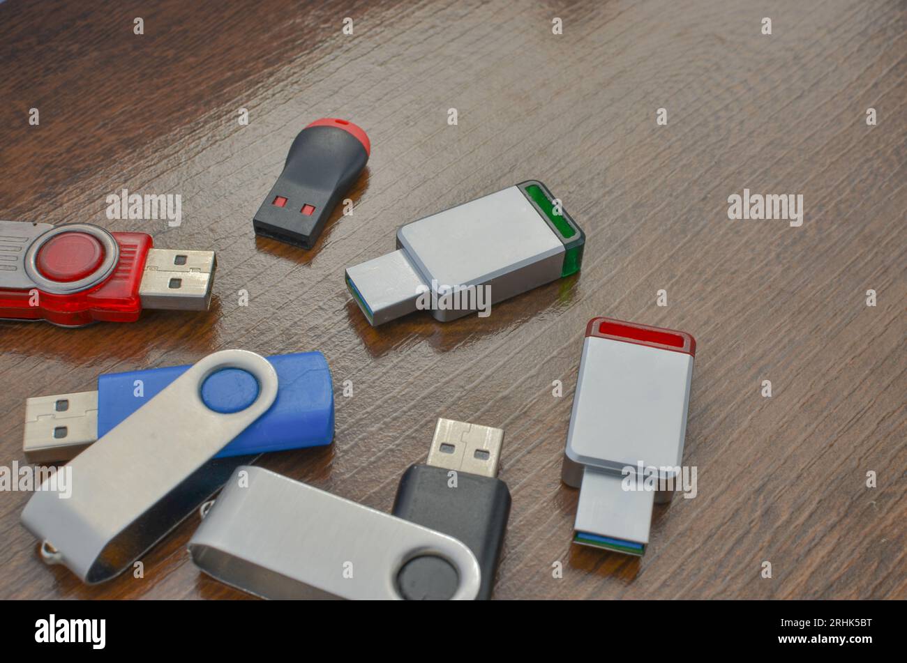 Nahaufnahme mehrerer USB-Sticks auf dem Holztisch. Mehrere verschiedene USB-Sticks. Flash-Laufwerke für mobile Datenspeicher und fortschrittliche Technologie. Stockfoto