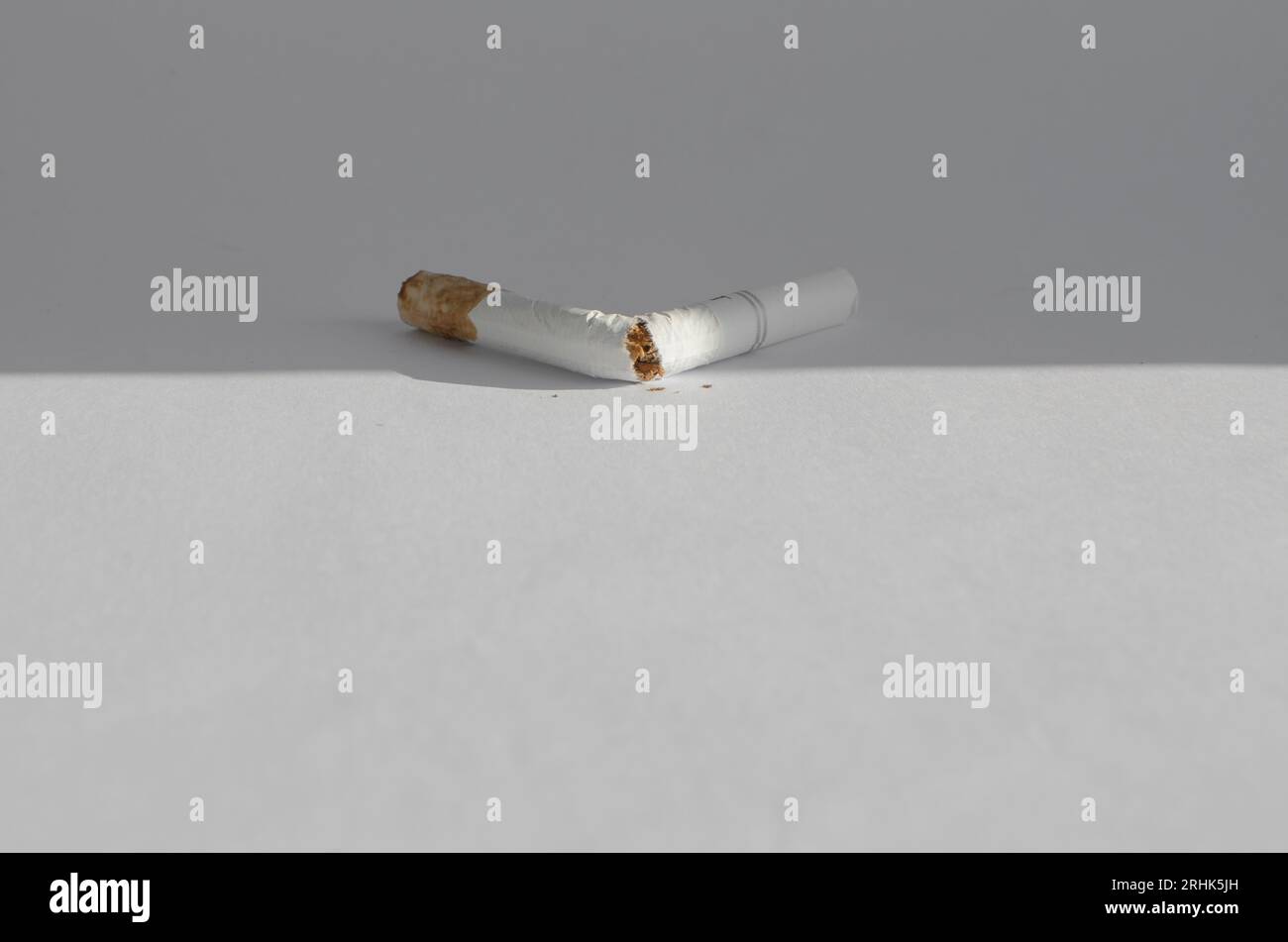 Details der Zigaretten auf einer weißen Oberfläche, die die gesundheitlichen Risiken und Krankheiten im Zusammenhang mit dem Rauchen symbolisieren. Stockfoto