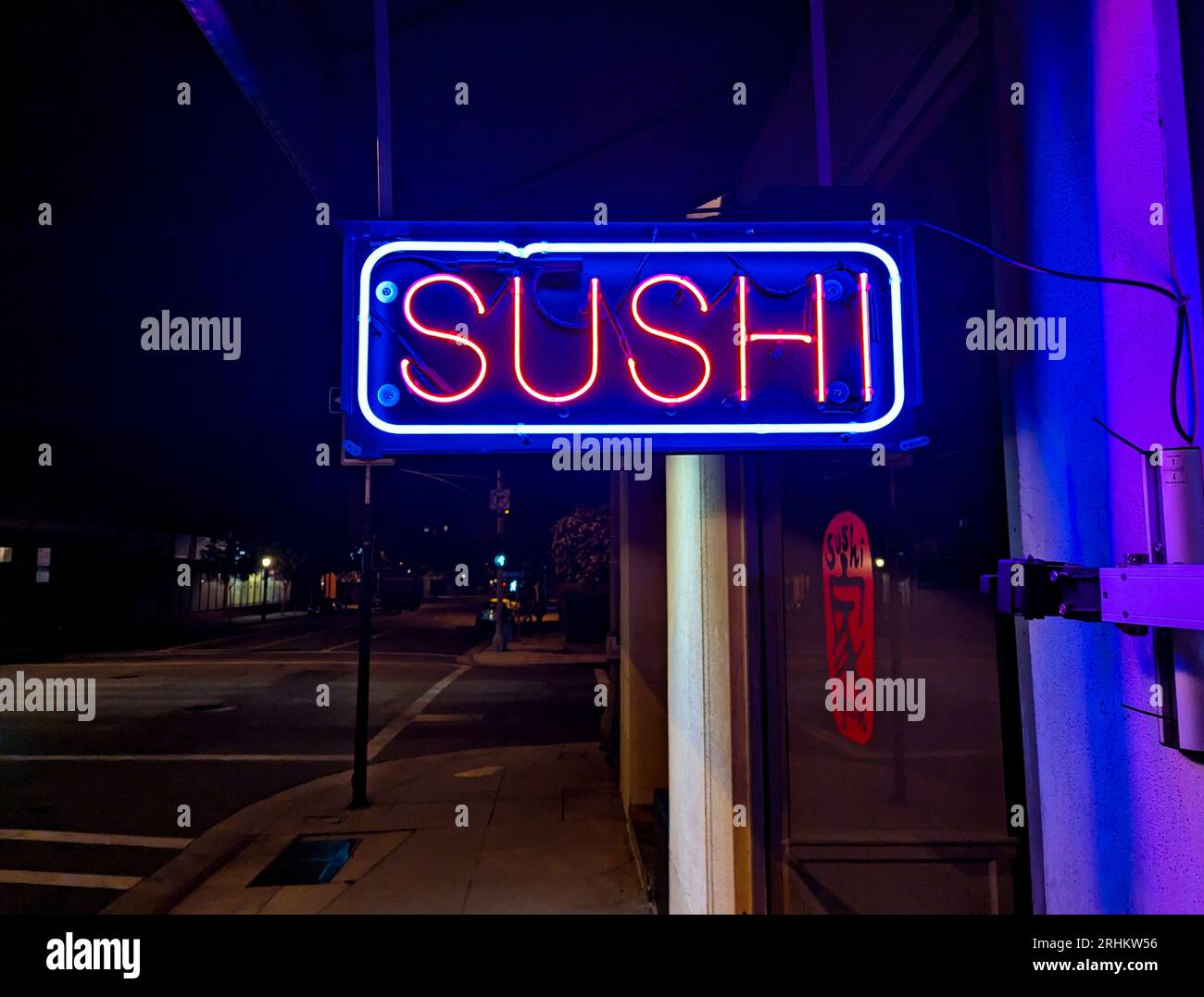 Ein neonfarbenes Sushi-Schild vor einem japanischen Restaurant Stockfoto