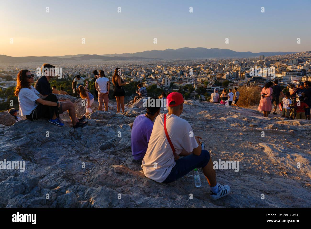 Athen, GR - 29. Juli 2023: Menschen, die den Sonnenuntergang auf dem Areopagus-Hügel betrachten Stockfoto