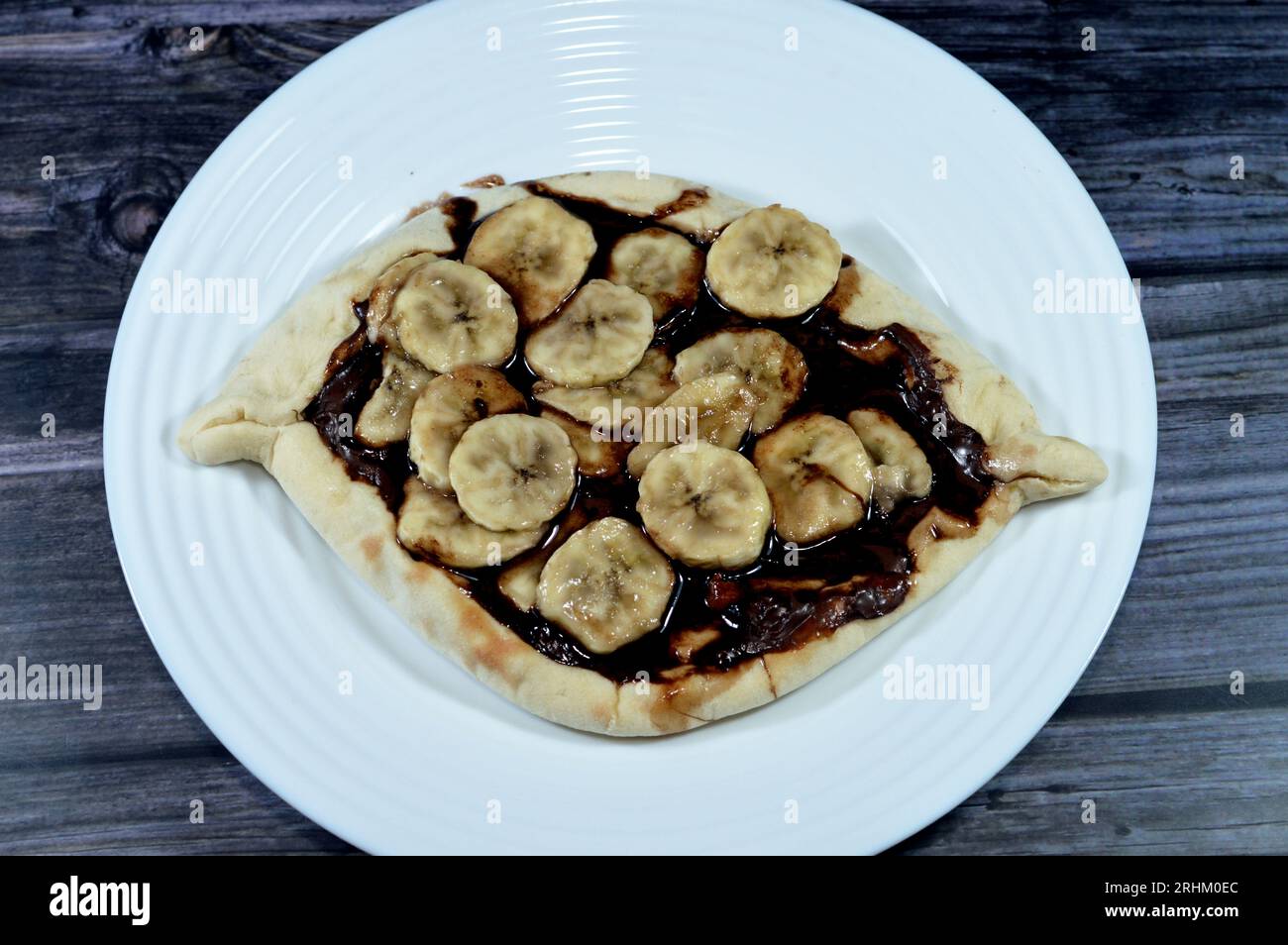 Chakhtoura, Ein süßes Gebäck aus Schokoladenkuchen, das im Ofen gebacken wird, dann mit schmelzender Schokolade bedeckt und mit Scheiben frischer Banane von Fr. gekrönt wird Stockfoto