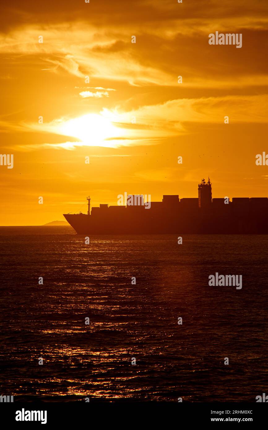 Silhouette eines Frachtschiffs bei Sonnenaufgang am Strand der copacabana in rio de Janeiro, brasilien. Stockfoto