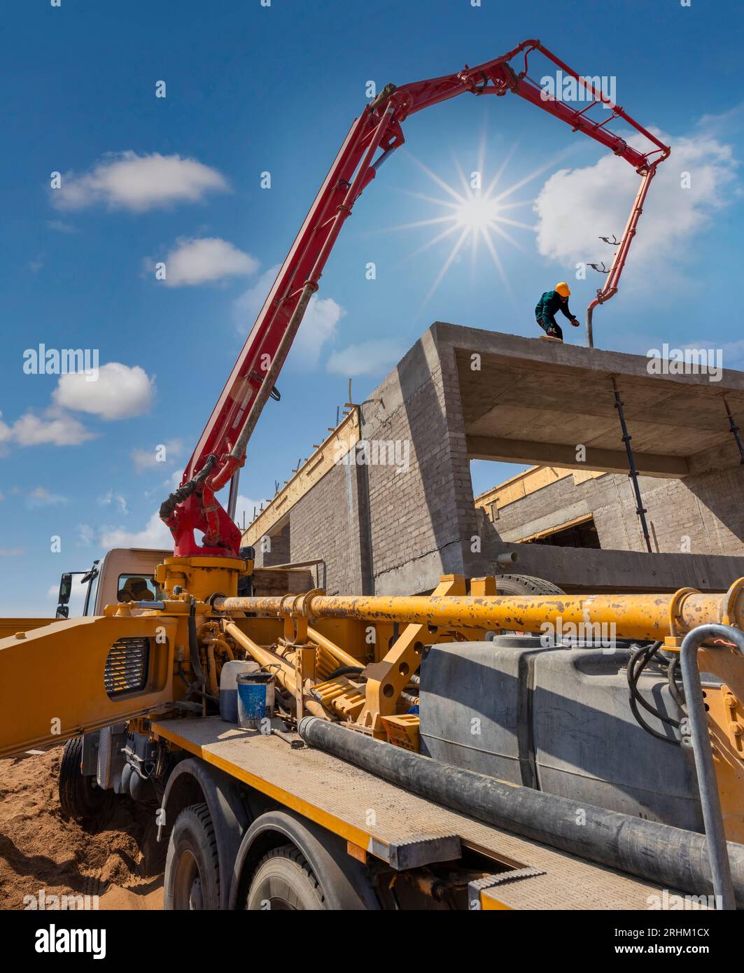 Betonpumpe, Betongießen auf die oberste Etage des afrikanischen Arbeiters in Betrieb Stockfoto