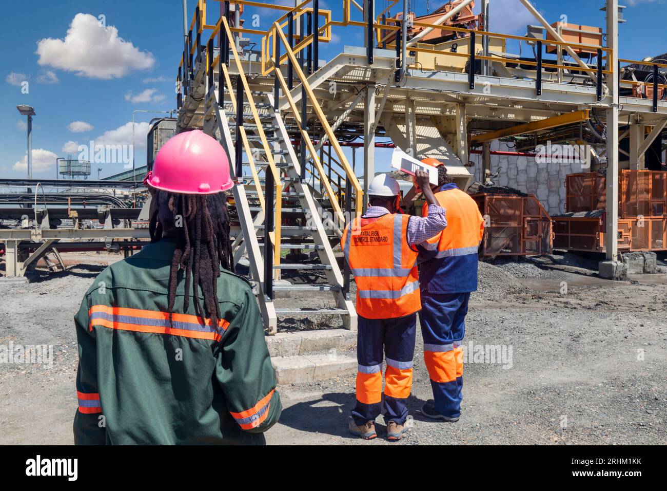 Mitarbeiter im Diamantenbergwerk, die Risiken kontrollieren und Produktionsdaten in einem Papiernotizbuch analysieren Stockfoto