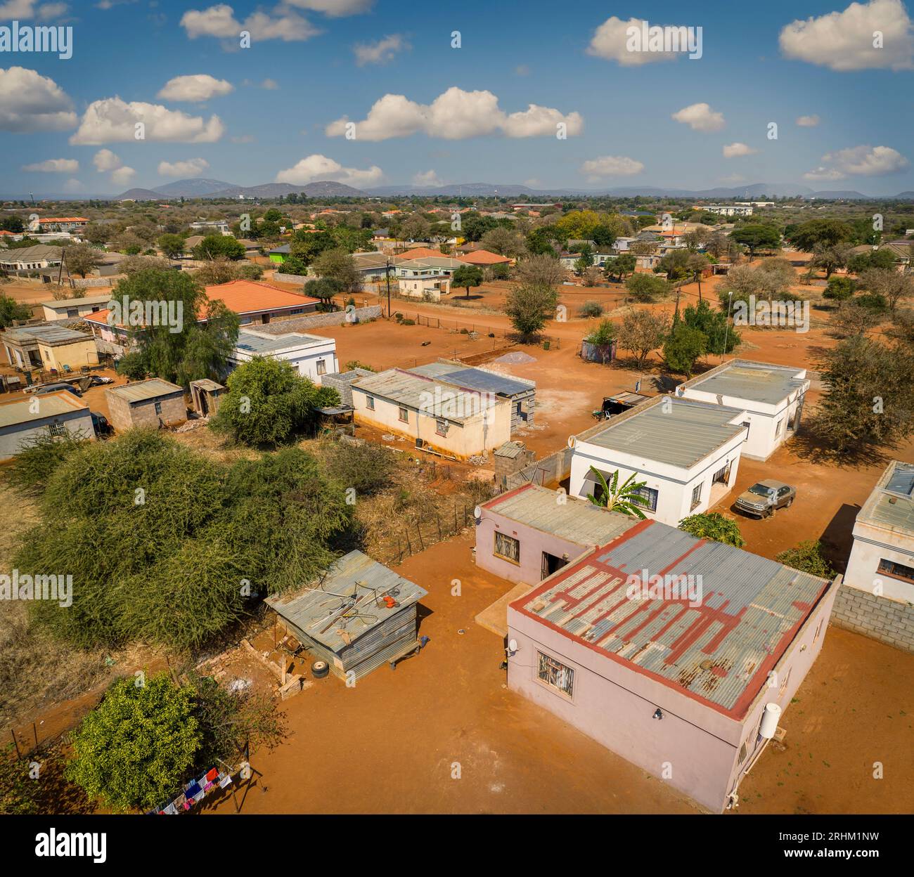 Luftaufnahme des typischen modernen afrikanischen Dorfes in botswana, mit staubigen unbefestigten Straßen und kubischen Gebäuden Stockfoto