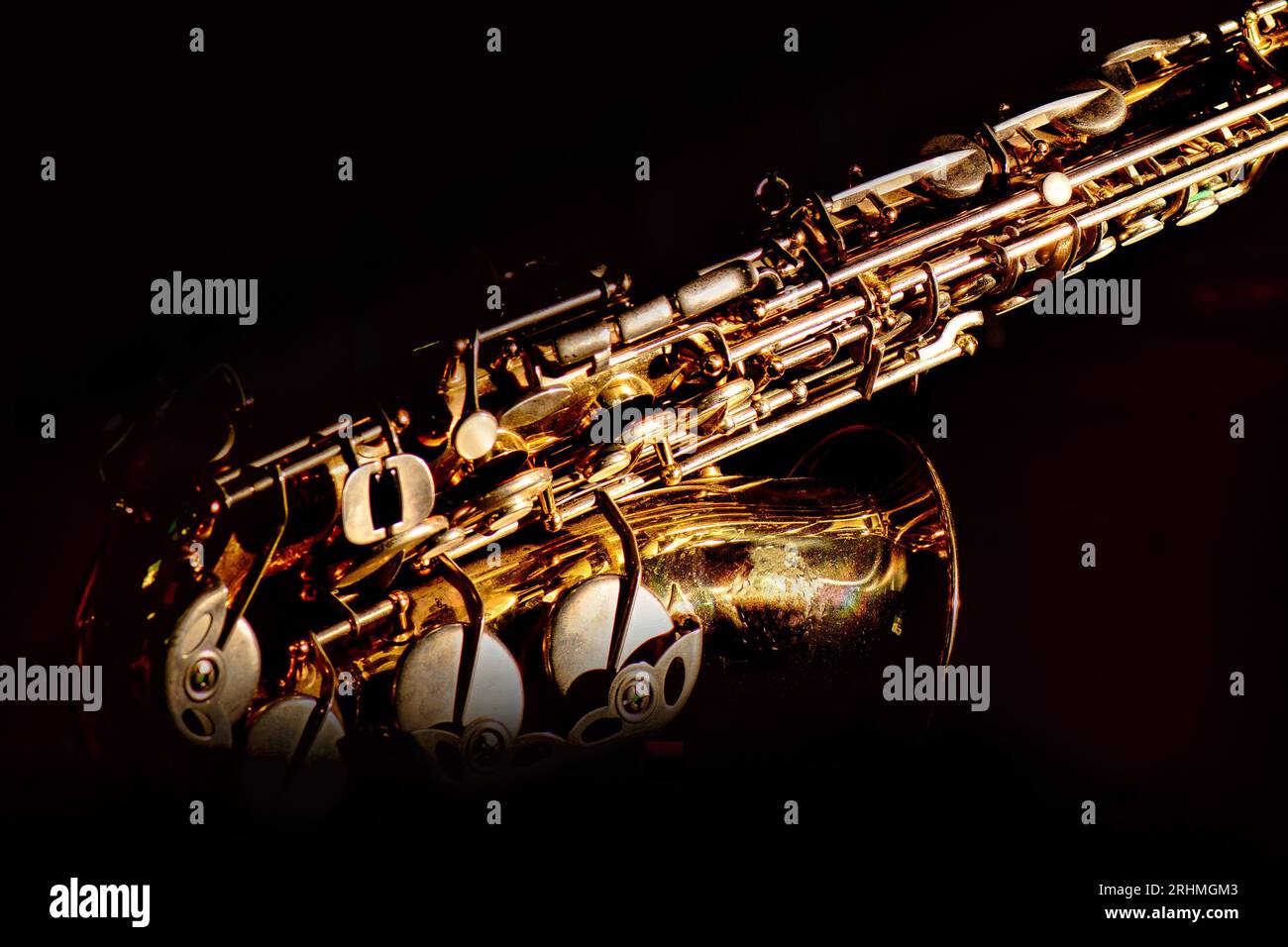 Detail eines goldfarbenen Saxophons auf schwarzem Hintergrund Stockfoto