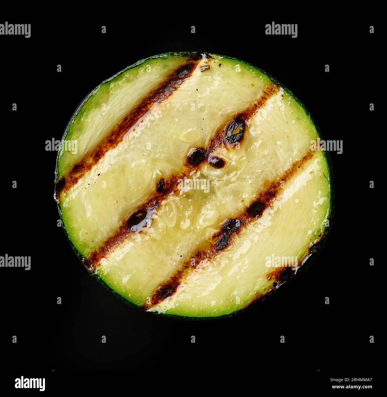 Gegrillte saftige Zucchini-Scheibe isoliert auf schwarzem Hintergrund, Draufsicht Stockfoto