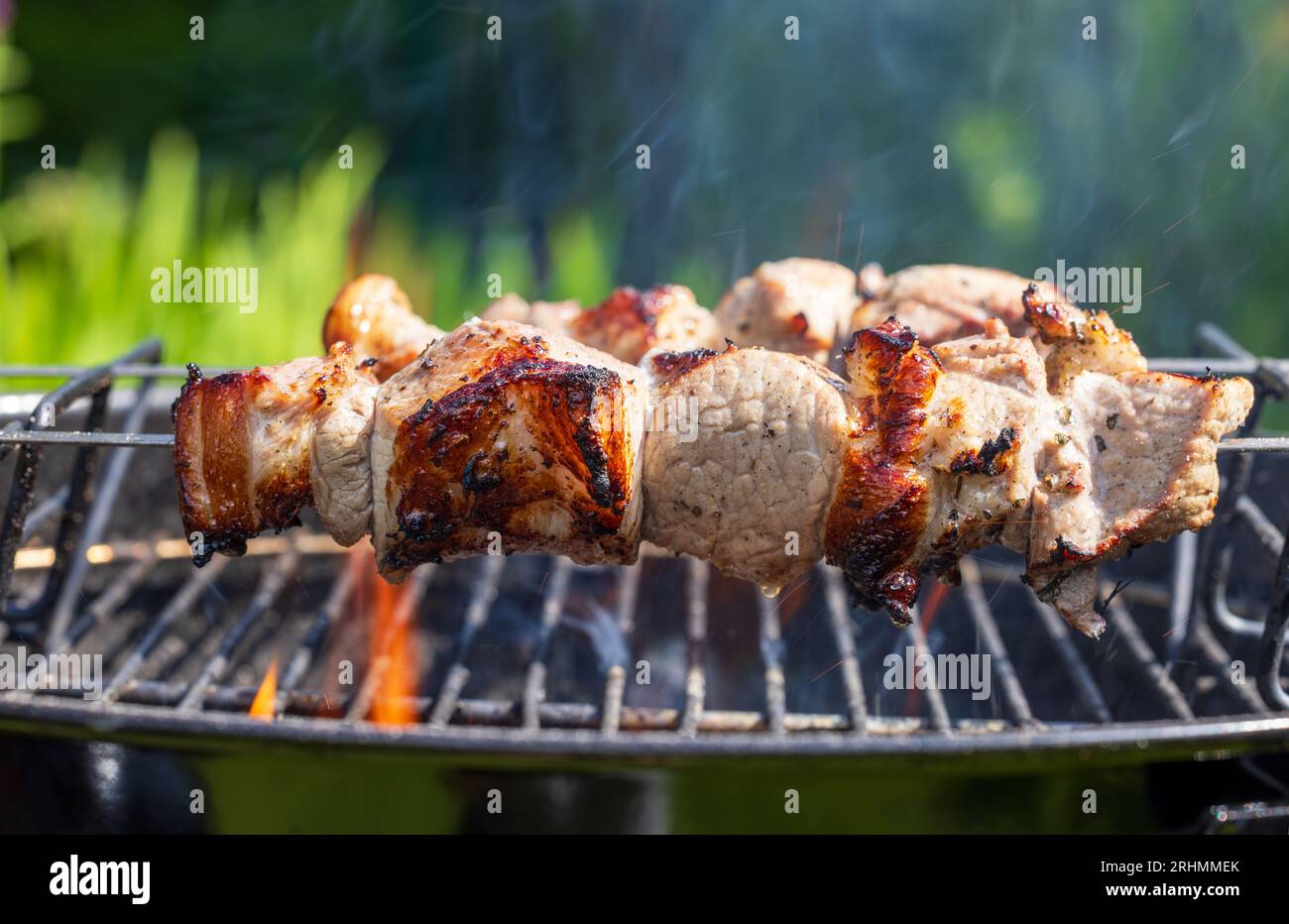 Gegrillte marinierte Schweinefleischspieße auf Holzkohlegrill Stockfoto