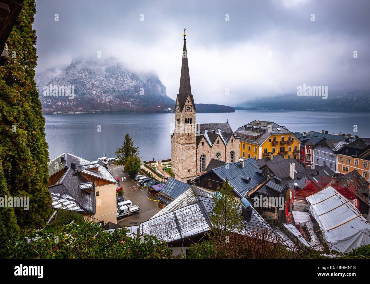 Hallstatt, Österreich - der weltberühmte Hallstatt, die zum UNESCO-Weltkulturerbe gehörende Stadt am See mit der Lutherischen Kirche Hallstatt an einem kalten nebligen Tag mit Schneefall Stockfoto