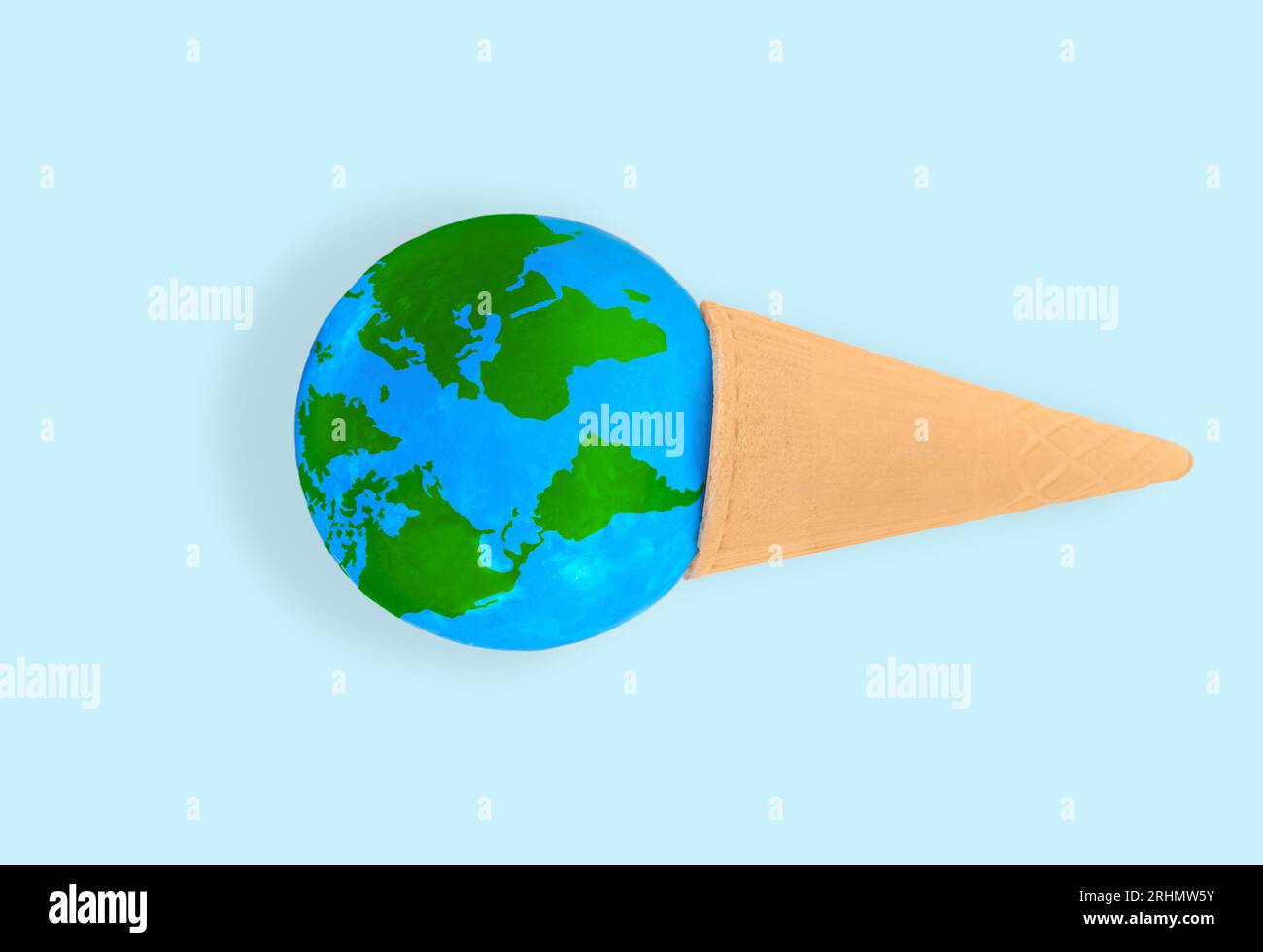 Kugel eingebettet in einen Waffelkegel isoliert auf blauem Hintergrund. Kreatives Fernweh und der Wunsch, die Welt zu erkunden. Stockfoto