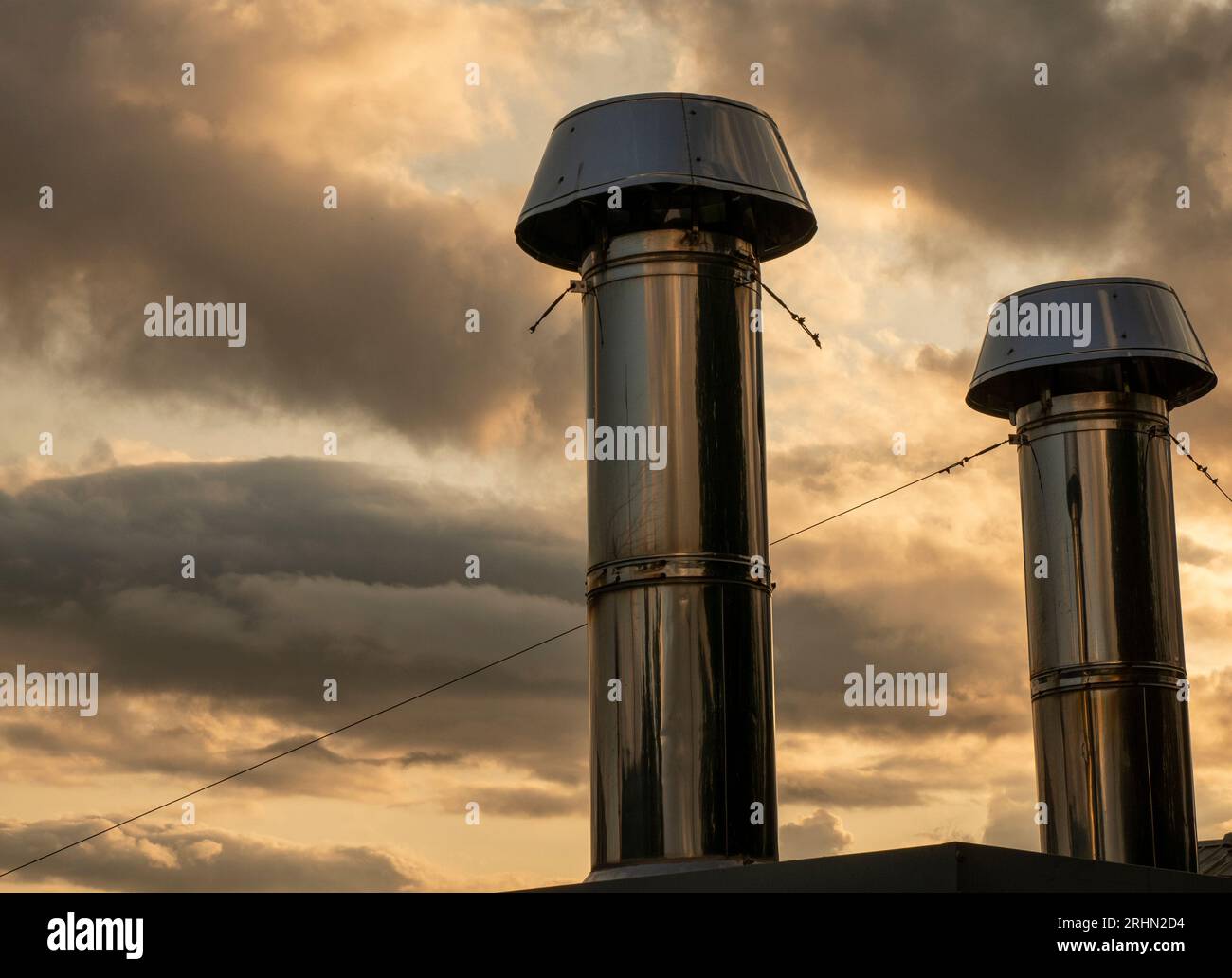 Industrielle Chromrohre über Sonnenuntergang Wolkenhintergrund Stockfoto