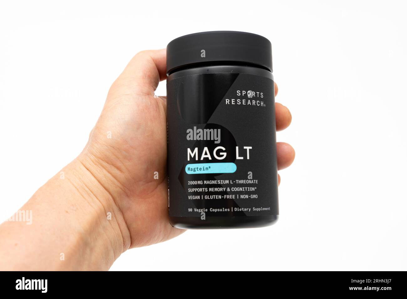 Fuji, Shizuoka, Japan - 27. Mai 2023: Hand Holding mag LT Magtein 2000 mg von Sports Research mit 90 vegetarischen Kapseln. Isoliert auf weißem Hintergrund Stockfoto