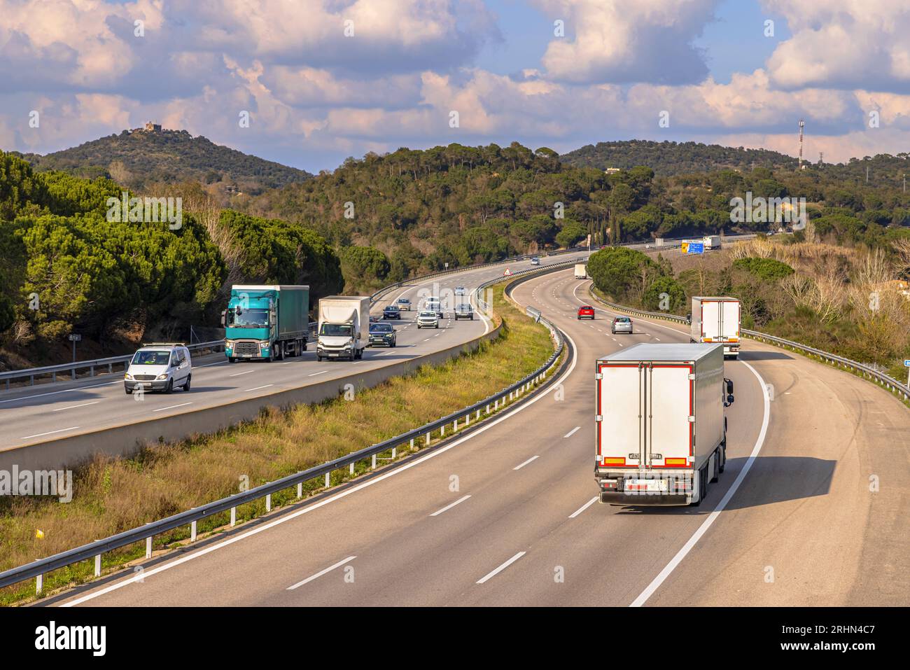 Sehen Sie über AP7 Autoroute de Mediterrania Freeway Traffic mit Güterwaggons und Weihnachtsverkehr. Katalonien, Spanien Stockfoto