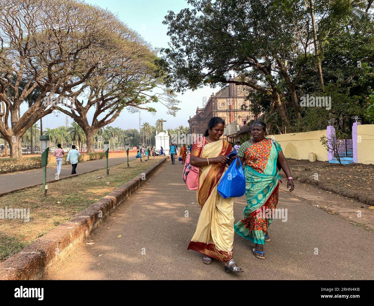 Old Goa, Indien - Januar 2023: Zwei indische Touristen laufen auf einer Straße an einem beliebten Touristenziel in Old Goa. Stockfoto